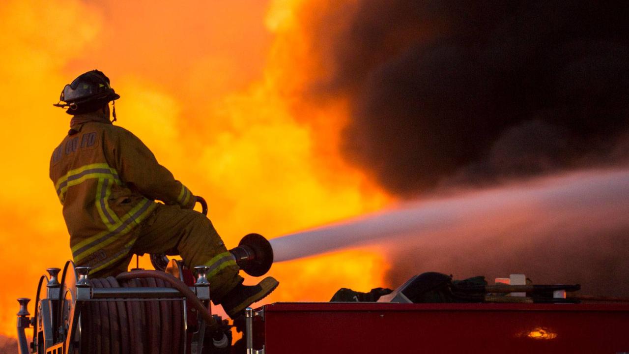 Firefighter shoots water at an active fire