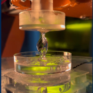 A robot arm pulls out a helix shape from resin