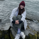 Woman sitting on a rock near a river or body of water