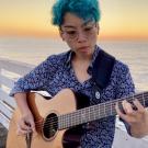 Kat Gallardo playing the guitar at the San Diego Pacific Beach Crystal Pier